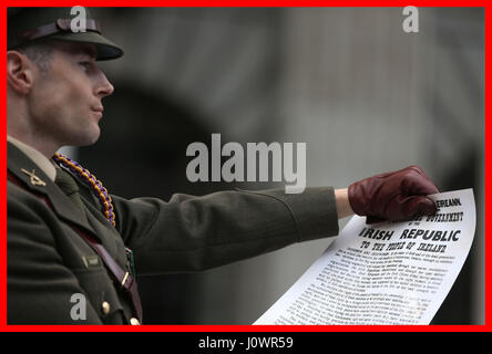 PABest capitano Michael Barry degli irlandesi Forze di Difesa trattiene una copia dell'annuncio durante una cerimonia per la 101st anniversario della Pasqua 1916 salendo al di fuori del GPO, in O&Atilde;•Connell Street Dublin. Foto Stock