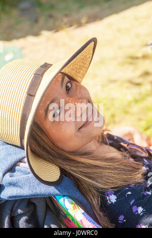 Ritratto di un bel giovane donna asiatica che indossa un cappello di paglia e chi sta guardando la telecamera con un leggero sorriso. Foto Stock