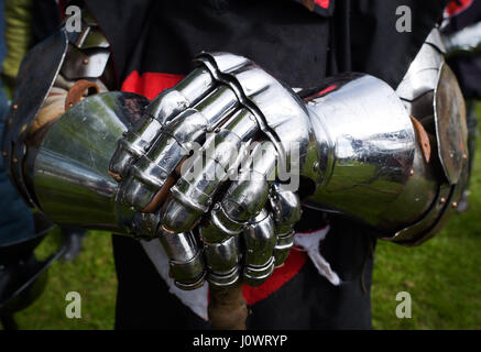 Un uomo vestito di cavalieri corazza attende in preparazione per una battaglia a Glastonbury weekend medievale, Abbazia di Glastonbury, nel Somerset. Foto Stock