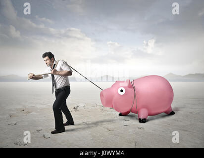 Imprenditore tirando salvadanaio Foto Stock