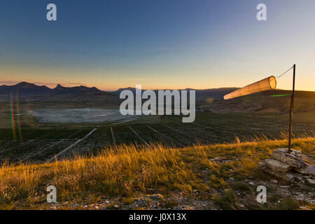 Parapendio antivento bianca al tramonto in montagna contro il sole Foto Stock