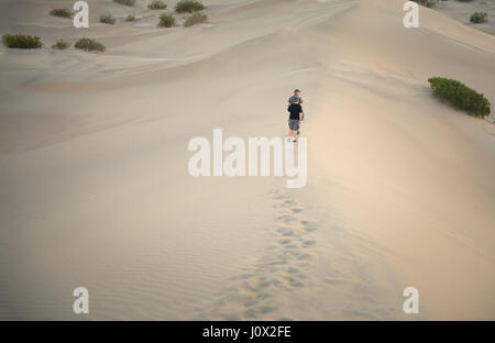 Uomo e suo figlio camminando lungo dune di sabbia, Death Valley, California, Stati Uniti Foto Stock