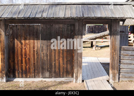 In legno porta rurale vicino alla vecchia casa in una giornata di primavera. Foto Stock