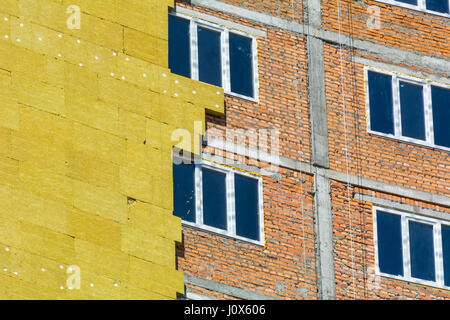 Ad alta altitudine lavorare sulle pareti esterne di isolante in lana di vetro e gesso Foto Stock