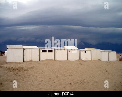 White cabine da spiaggia in una fila sulla spiaggia in Belgio Foto Stock