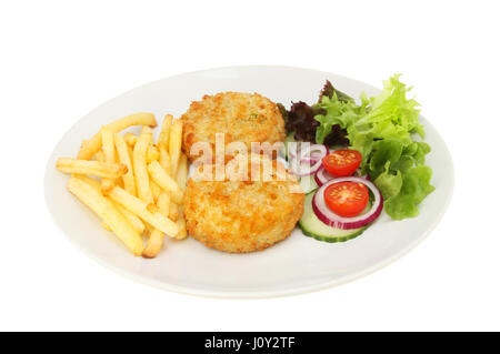 Torte di pesce patatine fritte e insalata su una piastra isolata contro bianco Foto Stock