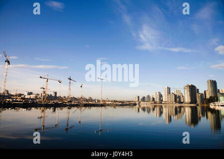 Lo skyline di Vancouver con gru edili e di riflessioni in acqua Vancouver, BC. Canada Foto Stock