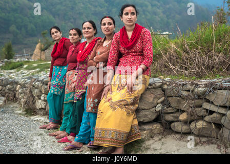 Ritratto di donne, abitanti di Khahare, in quanto si trovano vicino a un muro di gabione sul lato della pianura alluvionale di Harpan Khola a Kaski, Gandaki, Nepal. Foto Stock