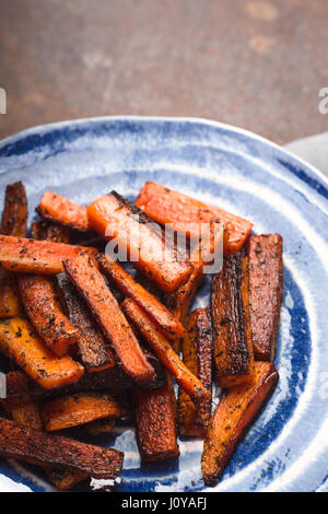Carote arrosto su piastra in ceramica sulla verticale della tabella Foto Stock