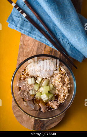 Zuppa di noodle ramen c sedano, pollo, daikon in una ciotola di vetro verticale Foto Stock