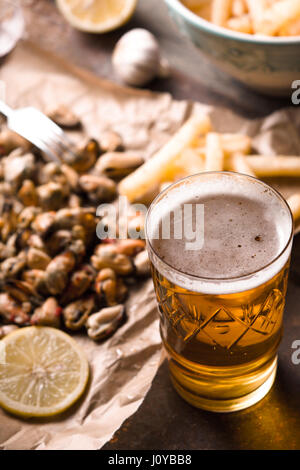 Bicchiere di birra con snack sfocata in verticale Foto Stock