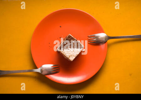 Torta al cioccolato con scaglie di noce di cocco su una piastra di ceramica Foto Stock