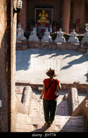 Tourist Woman in hat foto e fotocamera in antico complesso buddista in Ayutthaya parco storico, Thailandia Foto Stock