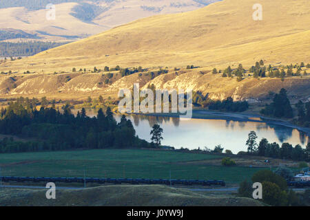 Vista della montagna, alberi, del lago e del movimento del treno da National Bison Range in Montana. Santuario protetto è uno dei più antichi National Wildlife Ref Foto Stock