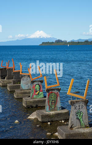 Dipinti murali la decorazione di un molo abbandonato sul Lago Llanquihue in Puerto Varas, Cile meridionale. Snow capped vulcano Osorno (2,652 metri) nella distanza. Foto Stock