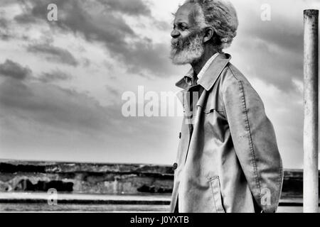 Il vecchio uomo cubano in un trench coat in Havana, Cuba Foto Stock