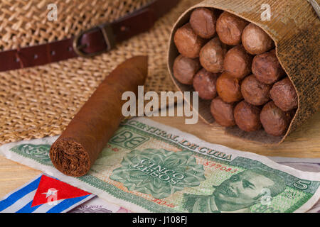 La Siesta - sigari, cappello di paglia e banconote cubano su un tavolo di legno Foto Stock