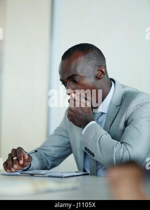 Ritratto di annoiarsi e sleepy afro-americano di imprenditore a sbadigliare seduti al tavolo riunione in ufficio moderno Foto Stock
