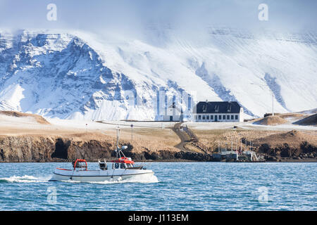 Piccola barca da pesca va nella baia di Reykjavik, Islanda Foto Stock