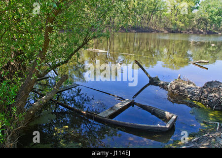 Immerso vecchio danneggiato la barca di legno nel letto del fiume. Foto Stock