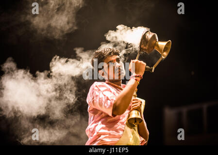 Younf India sacerdote maschio conducendo aarti rituale dedicato al fiume Gange a Varanasi Foto Stock