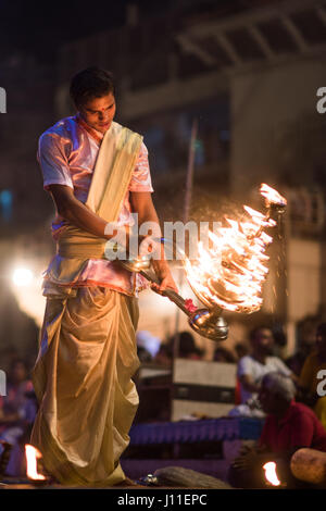 Younf India sacerdote maschio conducendo aarti rituale dedicato al fiume Gange a Varanasi Foto Stock