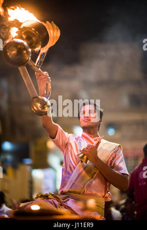 Younf India sacerdote maschio conducendo aarti rituale dedicato al fiume Gange a Varanasi Foto Stock