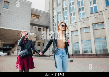 Due belle donne sorridente camminando per la strada in una giornata di sole Foto Stock
