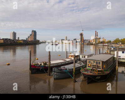 Case galleggianti sul fiume Tamigi a Chelsea con la fine del mondo e Chelsea Harbour in distanza, London, England, Regno Unito Foto Stock