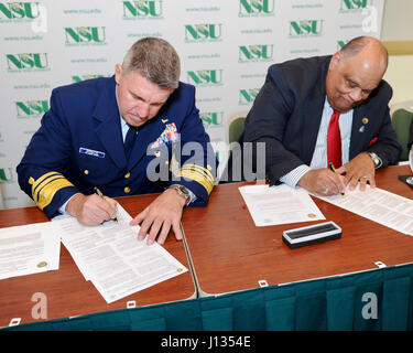 Vice Adm. Karl Schultz, commander, U. S. Coast Guard area atlantica, segni di un memorandum di intesa con il Sig. Eddie Moore, Jr., Presidente di Norfolk State University, la formalizzazione di un partenariato tra la Guardia Costiera e Norfolk State University per lo studente universitario Pre-Commissioning iniziativa (CSPI) programma Marzo 27, 2017. Il CSPI programma aiuta gli studenti iscritti o accettati per la registrazione in un tempo-pieno corso di laurea il programma a una istituzione qualificata, completare il programma e ricevere una commissione come un ufficiale della Guardia Costiera al completamento. U. S. Coast Guard foto di Auxiliarist Foto Stock