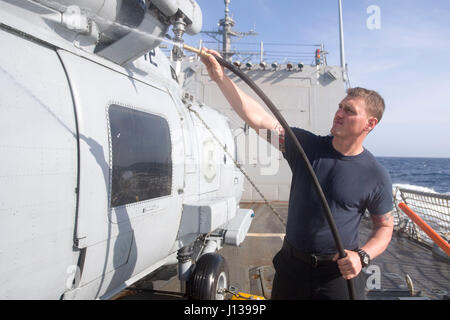 170410-N-DA095-049 OCEANO PACIFICO (10 aprile 2017) Aviation Electronics Tecnico 2a classe Justin Jarvis, da San Diego, tubi flessibili verso il basso un MH-60R Sea Hawk elicottero dal 'Magicians' di elicottero Maritime Strike Squadron (HSM) 35 a bordo della Arleigh Burke-class guidato-missile destroyer USS Shoup (DDG 86) mentre è in corso di realizzazione per un composito unità di addestramento esercizio (COMPTUEX) con il vettore Nimitz Strike gruppo in preparazione per una prossima distribuzione. Prove COMPTUEX la missione disponibilità dello sciopero del gruppo attività attraverso la simulazione di scenari del mondo reale e la loro capacità di eseguire come un integr Foto Stock