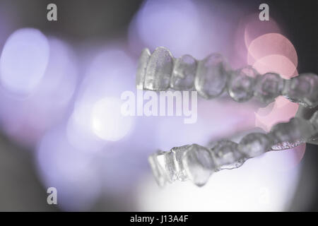 Invisibile ortodonzia dentale su sfondo colorato Foto Stock