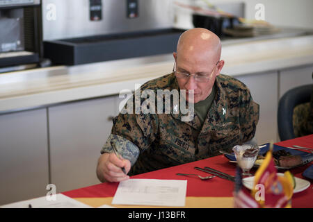 Stati Uniti Marine Corps Col. Richard F. Fuerst, comandante della Marine Corps Air Station Iwakuni, compila un modulo di giudizio dopo la degustazione di un piatto durante un Food Service Specialist del quarto concorso in ICM Iwakuni, Giappone, 13 aprile 2017. Il Food Service Specialist del trimestre è una lunga tradizione entro il Marine Corps food service community ed è progettato per consentire il servizio di ristorazione Marines per mostrare e dimostrare le loro singole abilità culinarie. (U.S. Marine Corps photo by Lance Cpl. Giuseppe Abrego Foto Stock