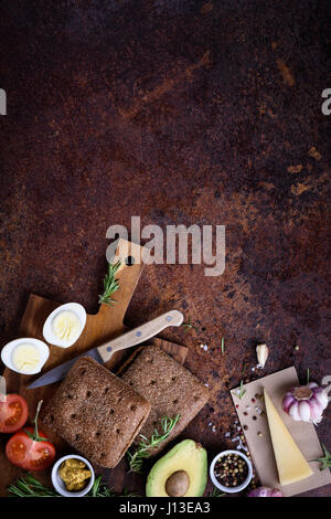 Hamburger Vegetariano con avocado, formaggio e uova sulla tavola di legno. Vista superiore, piatto laici. Vegetariano. Foto Stock