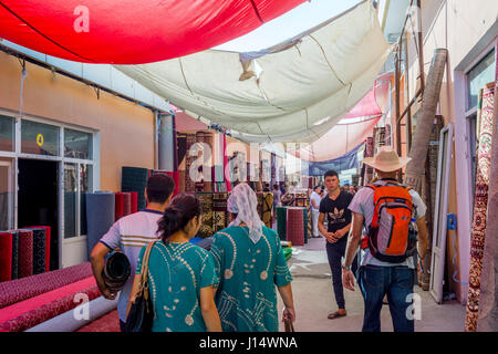 MARGILAN, Uzbekistan - 21 agosto: la gente camminare accanto a molti negozi di tappeti a Kumtepa bazaar. Il mercato è uno dei più grandi nella zona in esecuzione una volta Foto Stock