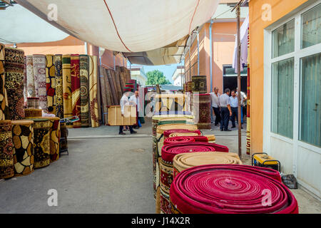 MARGILAN, Uzbekistan - 21 agosto: la gente camminare accanto a molti negozi di tappeti a Kumtepa bazaar. Il mercato è uno dei più grandi nella zona in esecuzione una volta Foto Stock