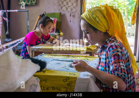 MARGILAN, Uzbekistan - 20 agosto: donna tessuto da ricamo a mano con i tradizionali modelli uzbeko in una fabbrica di seta workshop. Agosto 2016 Foto Stock