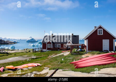 Kayak da mare capovolto su un terreno da coste con gli iceberg dal galleggiante offshore nella baia di Disko in estate. Ilulissat Tourist Nature (Jakobshavn) Groenlandia Foto Stock
