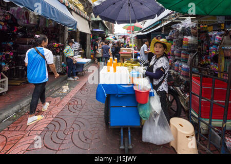 Succo di arancia venditore nella trafficata via dello shopping a Chinatown, Bangkok, Thailandia Foto Stock