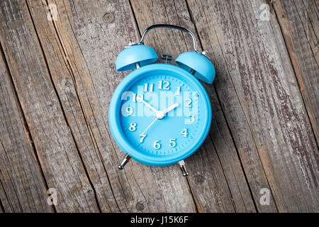 Blue sveglia su un vecchio tavolo in legno Foto Stock
