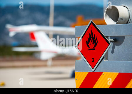 Vista posteriore del servizio e il rifornimento di carburante il carrello su un aeroporto con un aeromobile di sfondo sfocato. Rischio chimico, liquidi infiammabili. Foto Stock