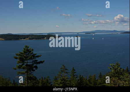 Barche a vela attorno alla zucca Island Lighthouse appena fuori dalla piccola isola di cervi nel Maine Foto Stock