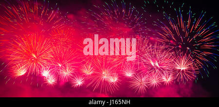 Fuochi d'artificio multicolore con cityscape di notte Foto Stock