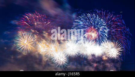 Fuochi d'artificio multicolore con cityscape di notte Foto Stock