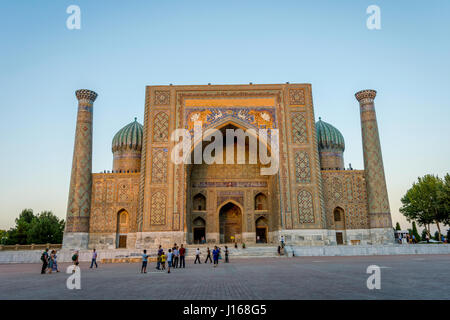 Samarcanda, Uzbekistan - 27 agosto: Gente di fronte Sher-Dor madrasah del Registan nel sole del pomeriggio. Agosto 2016 Foto Stock