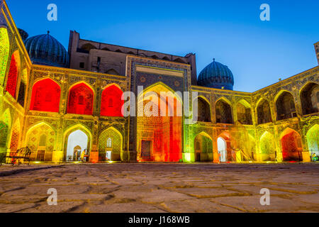 Colorato luminoso atrio di Sher-Dor Madrasah di notte, Samarcanda Registan, Uzbekistan Foto Stock