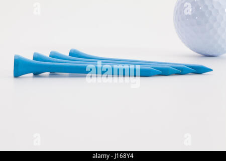 In legno di colore blu golf tees e pallina da golf sul tavolo bianco Foto Stock