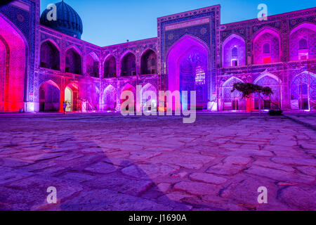 Colorato luminoso atrio di Sher-Dor Madrasah di notte, Samarcanda Registan, Uzbekistan Foto Stock