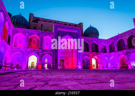 Colorato luminoso atrio di Sher-Dor Madrasah di notte, Samarcanda Registan, Uzbekistan Foto Stock