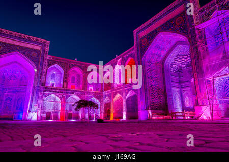 Colorato luminoso atrio di Sher-Dor Madrasah di notte, Samarcanda Registan, Uzbekistan Foto Stock